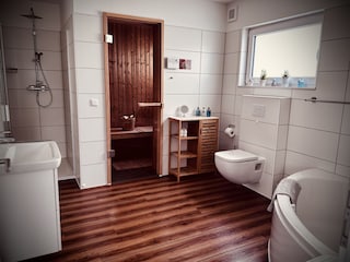Badezimmer mit Sauna, Dusche und Badewanne