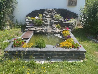 Kleiner Bachlauf mit Springbrunnen im Hausgarten