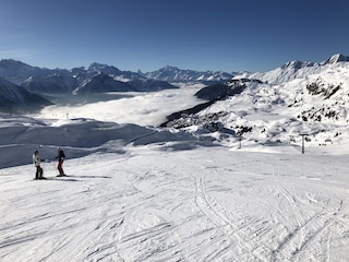 Skifahren in der Sonne hoch über dem Talnebel