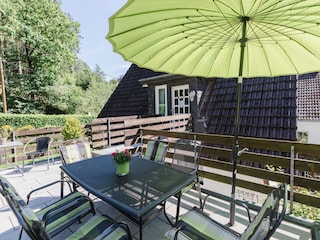 Terrasse mit Grill und großem Sonnenschirm