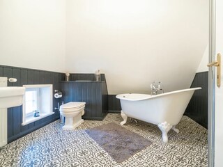 Das Badezimmer verfügt sowohl über eine Badewanne als auch eine bodengleiche Dusche.