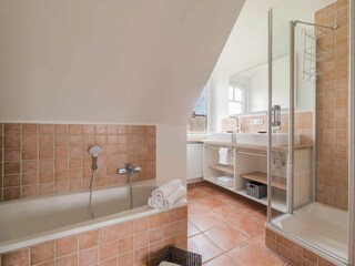 Dieses Badezimmer ist mit einer Dusche und einer Badewanne ausgestattet.
