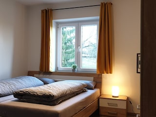 Schlafzimmer mit Doppelbett und Fernseher