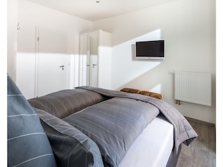 Schlafzimmer mit einem gemütlichen Boxspringbett und Fl