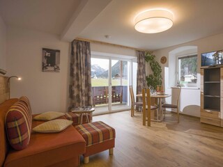 Wohnraum mit Couch, Esstisch und Stühlen