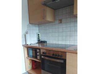 Küche mit Mikrowelle und Backofen