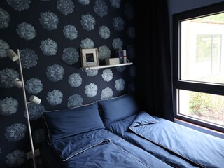 blaues Schlafzimmer mit Blick in den Garten