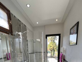 Freundliches Badezimmer mit Dusche, Waschtisch, WC und Fenster