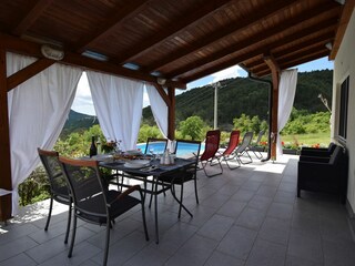 Große überdachte Terrasse mit hochwertigen Gartenmöbeln