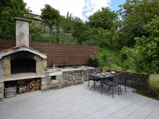 Terrasse hinter dem Haus mit gemauertem Kamin