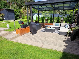 Überdachter Sitzbereich mit Kaminofen