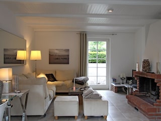 Das lichtdurchflutete Wohnzimmer mit Flat-TV und Kamin