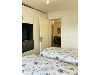 Schlafzimmer mit TV und großem Kleiderschrank mit Blick