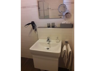 Waschbecken mit Fön und Kosmetikspiegel