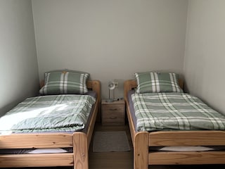 2 Einzelbetten im Schlafzimmer mit einem Tisch