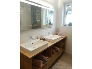Badezimmer mit Doppelwaschbecken und Dusche