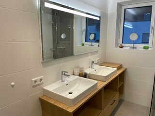 Badezimmer mit Doppelwaschbecken und Dusche