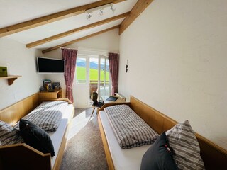 Schlafzimmer mit Smart-TV u. Zugang zum Südbalkon
