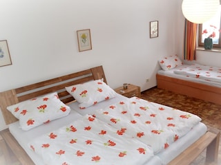 Schlafzimmer mit 3 Betten und Waschbecken