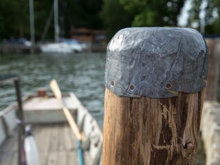 Holzdalben mit Fischerboot