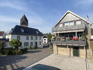 Hofstelle mit Parkplätzen im Vordergrund