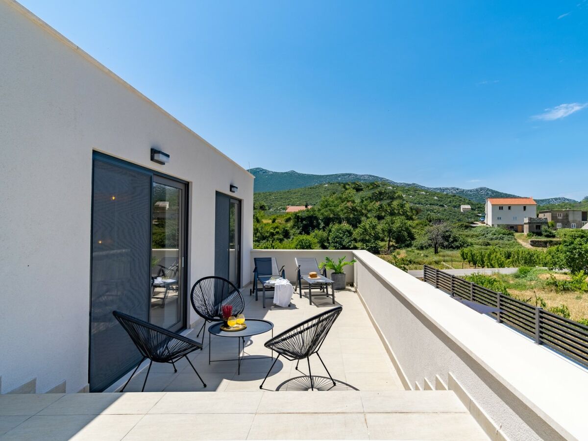 Terrasse mit Lounge-Ecke und Blick auf den Pool