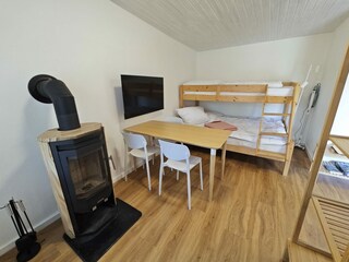 Wohnzimmer mit Kaminofen und Etagenbett