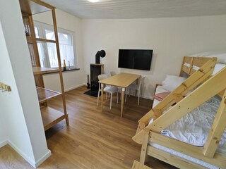 Wohnzimmer mit Kaminofen und Etagenbett