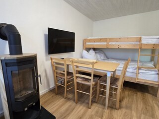 Wohnzimmer mit Kaminofen und Etagenbett