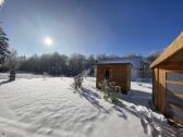 Gartenblick mit Sauna und Maar im Hintergrund