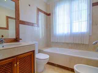 Voll ausgestattetes Badezimmer mit Badewanne