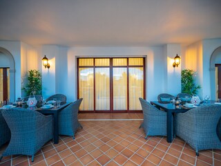 Terrace with dining table and rattan armchairs for 8 wi