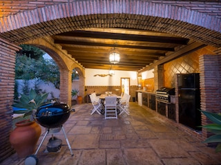 Barbecue area with dining table, kitchen counter