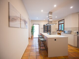 Fully equipped open plan kitchen with bar stools