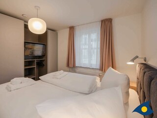 Schlafbereich mit Doppelbett und TV