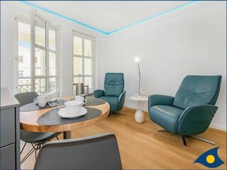 Wohnbereich mit offener moderner Küche und Zugang zum Balkon