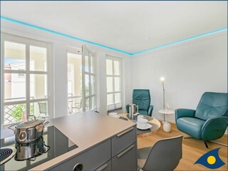 Wohnbereich mit offener moderner Küche und Zugang zum Balkon