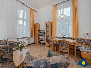 Wohnzimmer mit Schlafcouch und Essecke