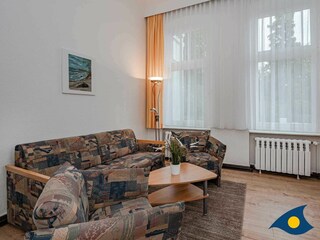 Wohnzimmer mit Schlafcouch und Essecke