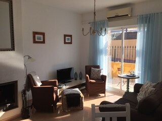 Sitting-room with airco, open fire and all tv channels.