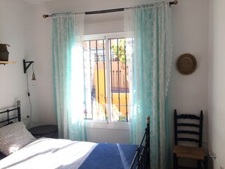 Hauptschlafzimmer mit hochwertigem Bett und Ventilator.