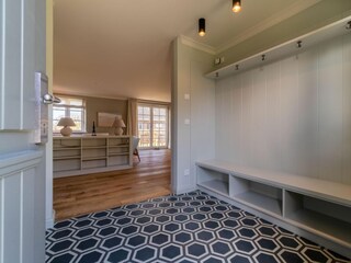 Die handgefertigte Garderobe bietet ausreichend Platz für Jacken und Schuhe.