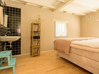 Schlafzimmer 1 mit Doppelbett, Schrank und Waschbecken