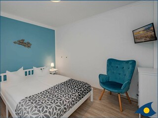 Schlafbereich mit Doppelbett und TV