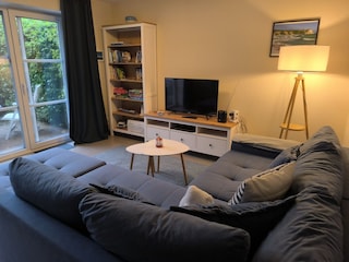 Wohnzimmer mit Schlafsofa und Ausgang zur Terrasse