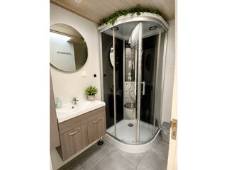 Voll ausgestattete Dusche mit Duschkabine inklusive Reg