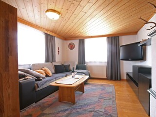 Wohnzimmer mit Couch und Flat-TV