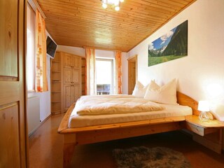 Schlafzimmer mit Doppelbett und TV