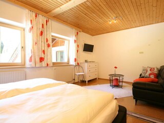 Schlafzimmer mit Couch und TV