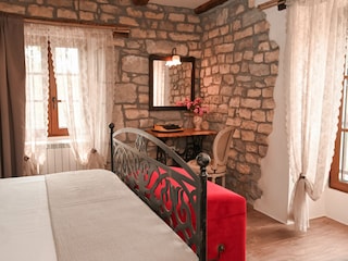 Romantisches Schlafzimmer mit freigelegten Steinwänden